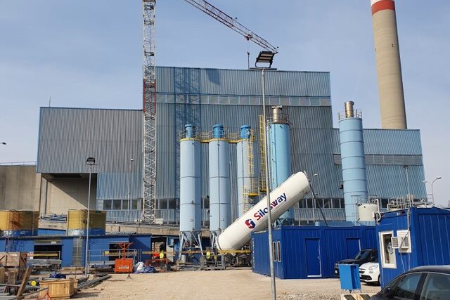 Müllverbrennungsanlagen in der Bauphase: Anlage in Trieste, Italien, kesselhaus, teil des kamins mit hellblauen silos im Vordergrund